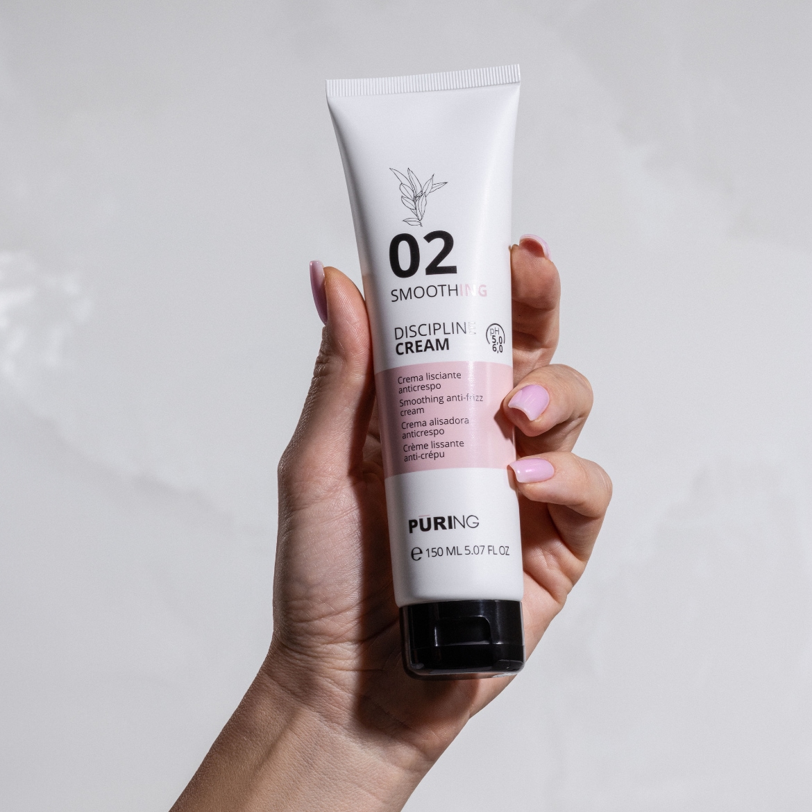 Rankoje laikomas baltas „Puring 02 Smoothing Discipline Cream“ tubelis su rausva etikete, skirtas glotninti ir mažinti plaukų pūtimąsi, kurio pH yra 5,0–6,0, o talpa – 150 ml.