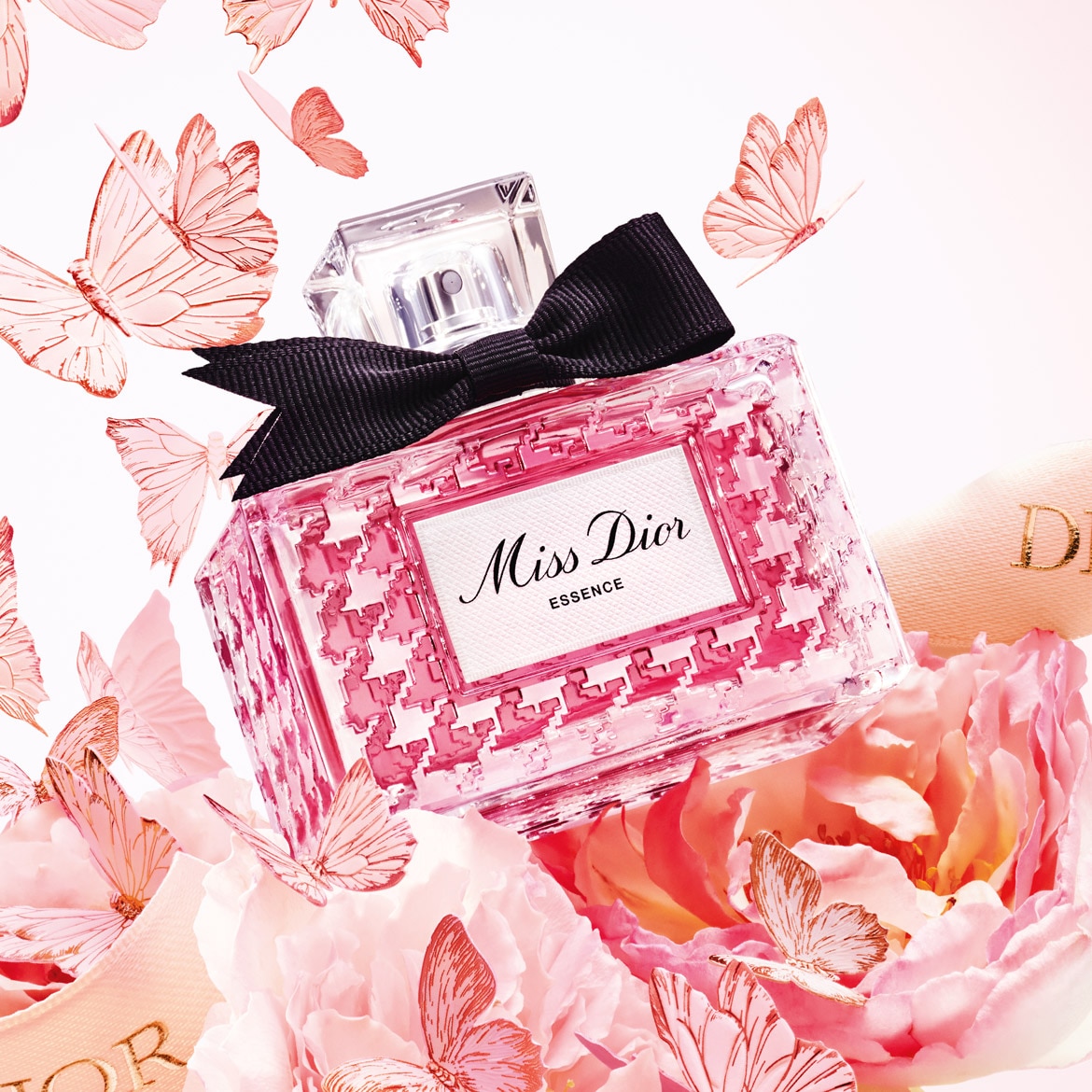 Šis „Miss Dior Essence“ buteliukas, papuoštas juodu kaspinu, apsuptas rožinių gėlių ir drugelių, suteikia elegancijos ir žavesio.