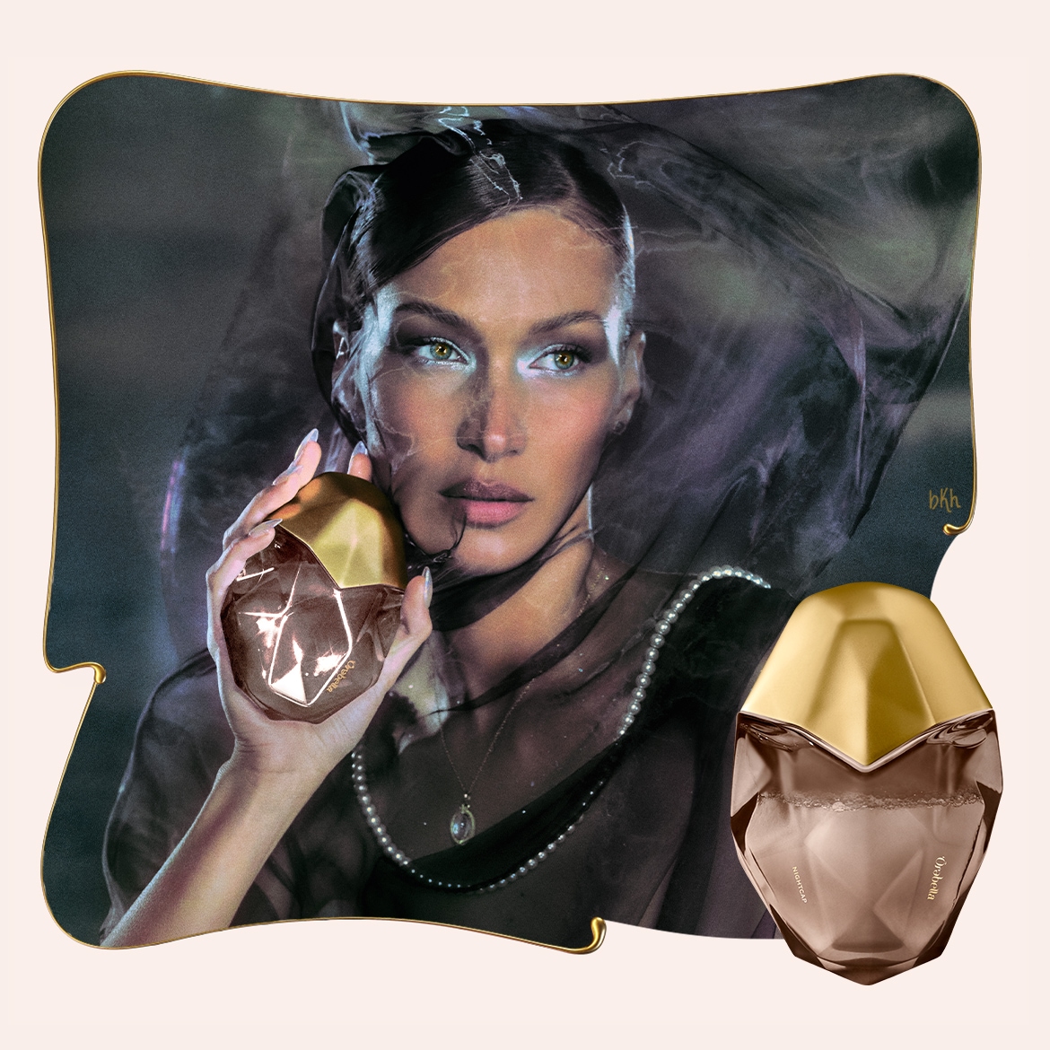 Nuotraukoje matyti moteris su skaidriu šydu ant galvos, laikanti rudos spalvos kvepalų buteliuką su auksiniu dangteliu, šalia stovi kitas toks pat buteliukas.