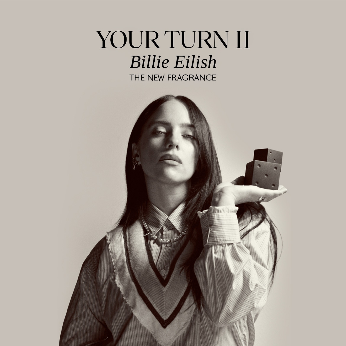 Reklama su tekstu „Your Turn II Billie Eilish – The New Fragrance“, centre – asmuo laiko kvepalų buteliuką prie veido.