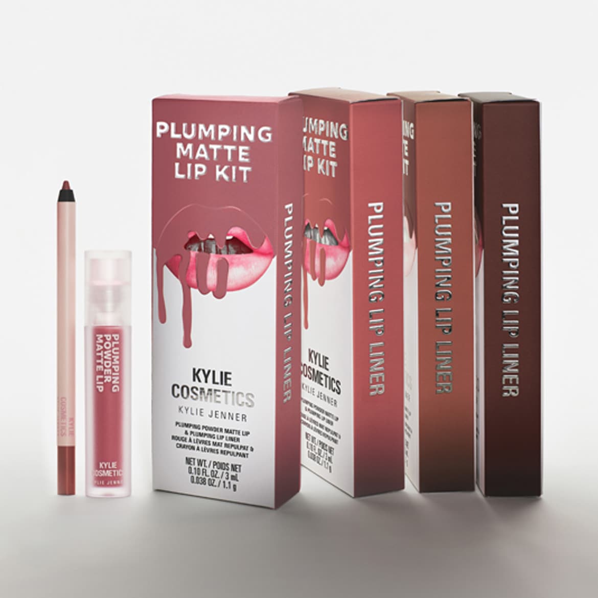 Kylie Cosmetics Plumping Matte lūpų rinkinys, kurį sudaro lūpų pieštukas, skysti matiniai lūpų dažai ir keturios Plumping lūpų pieštukų pakuotės, yra išdėstytas ant balto fono.