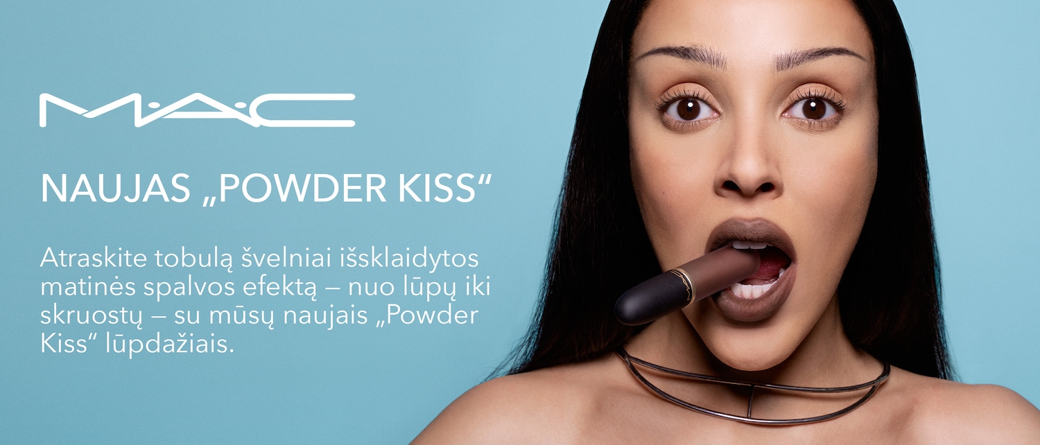 Discover the new MAC "Powder Kiss" lipstick for a perfectly soft, matte color effect from lips to cheeks, as a woman playfully holds the brown lipstick in her mouth.
