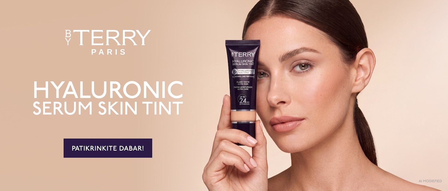 Moteris laiko rankoje BY TERRY Hyaluronic Serum Skin Tint tamsiai violetinį tūbelės formos serumą, o šalia matomas užrašas PATIKRINKITE DABAR!