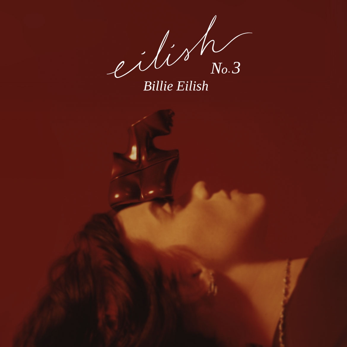 Billie Eilish pristato Eilish No.3, naująjį aromatą, supakuotą į metalinį biustą ant raudono fono.