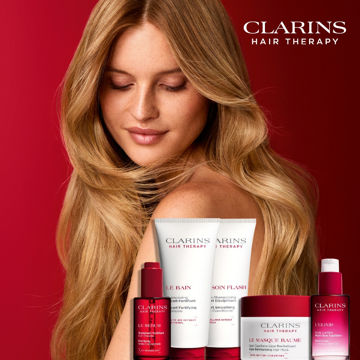 Šviesiaplaukė moteris užsimerkusi, jos plaukai krenta ant pečių, o priešais ją – „Clarins Hair Therapy“ plaukų priežiūros priemonių linija, kurią sudaro šampūnas, kondicionierius, serumas, kaukė ir aliejus.