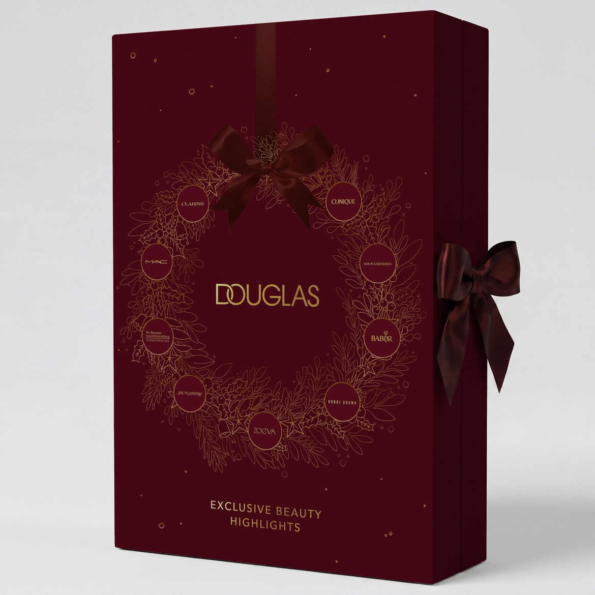 Raudonos spalvos dovanų dėžutė su auksiniu vainiku, papuošta kaspinu, su užrašu „DOUGLAS EXCLUSIVE BEAUTY HIGHLIGHTS“ ir prekių ženklų logotipais.