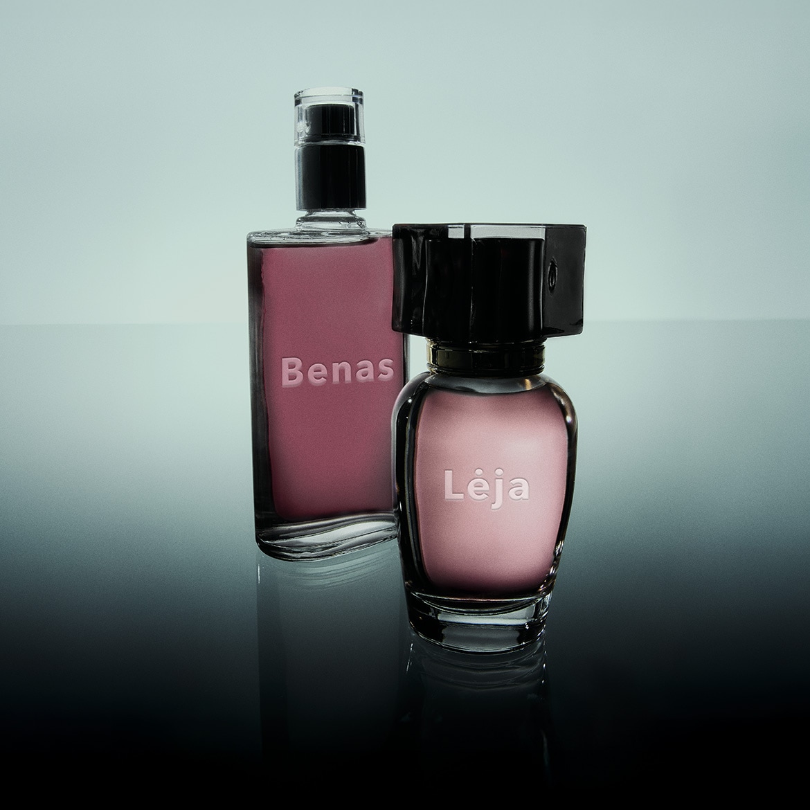 Du buteliukai kvepalų „Bena“ ir „Lėja“ su rausvu skysčiu ir juodais kamšteliais ant blizgaus paviršiaus.