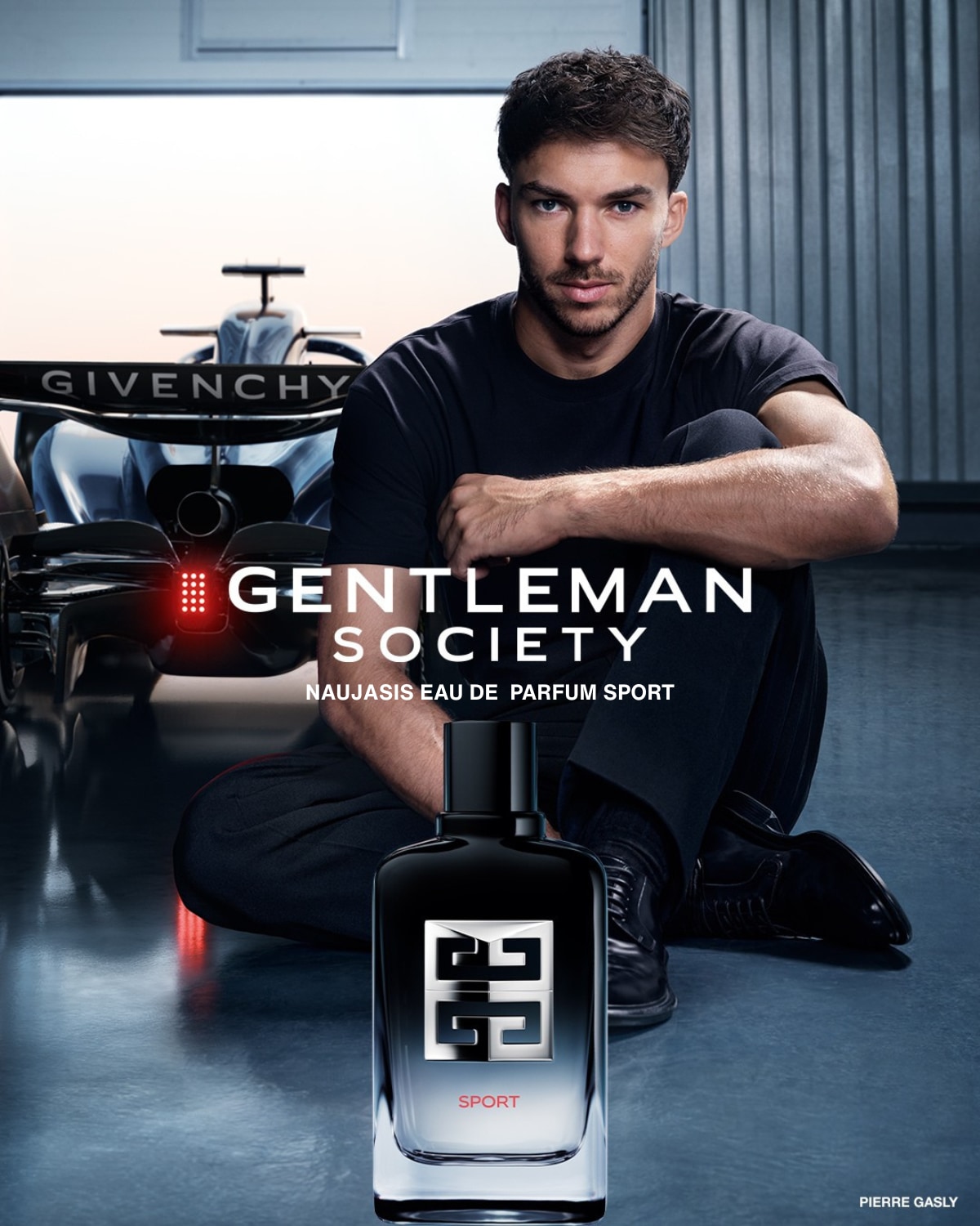 Pierre Gasly reklamuoja „Gentleman Society“ „Naujasis Eau de Parfum Sport“ su juodu buteliuku ir lenktyniniu automobiliu fone.