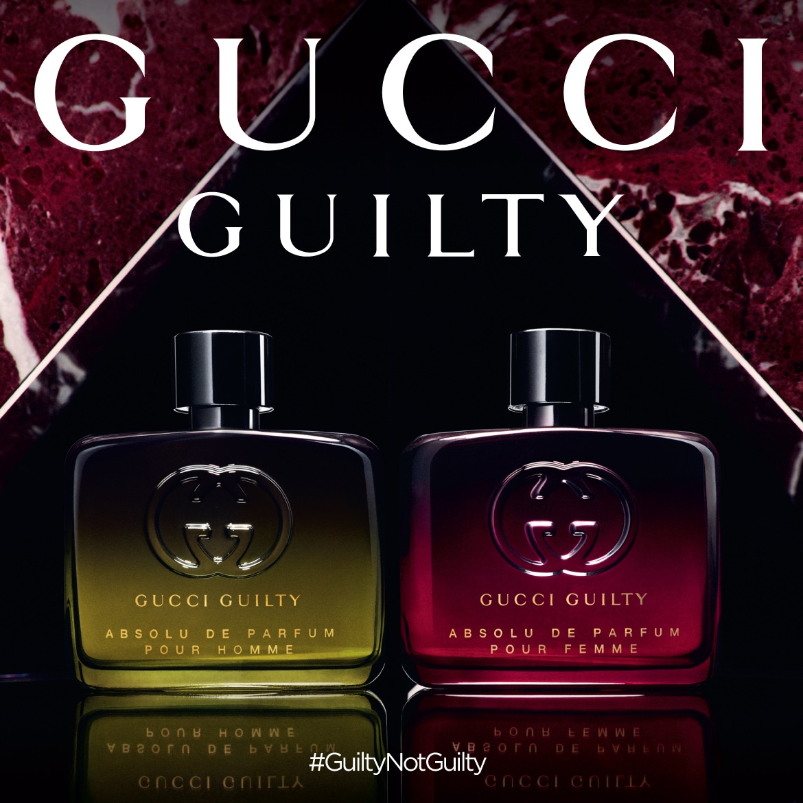 A pair of Gucci Guilty Absolu de Parfum bottles, one for men in a warm yellow tone and one for women in a rich red, set against a dark backdrop with a marble accent, embodying luxury.