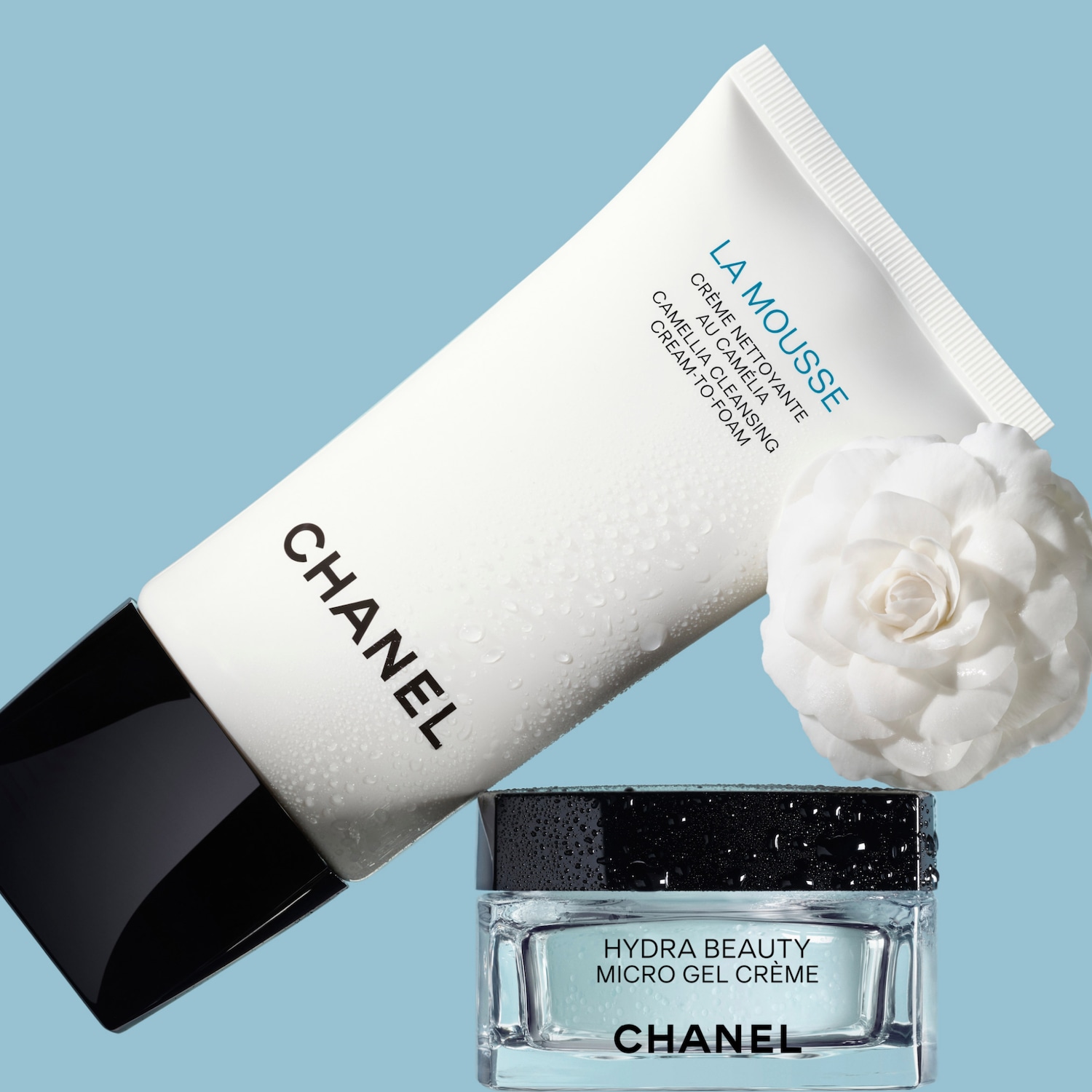CHANEL La Mousse prausiklis ir Hydra Beauty Micro Gel Crème kremas su baltomis kamelijomis mėlyname fone.