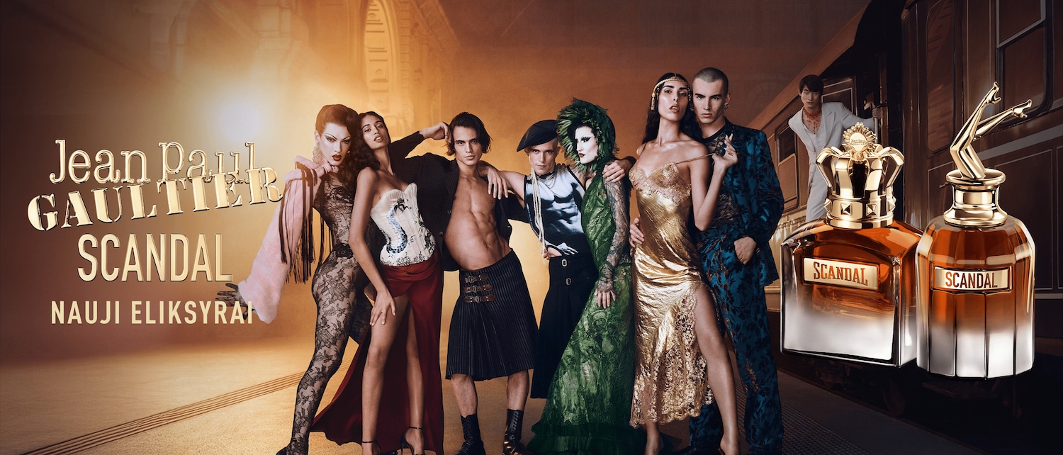 Reklaminis plakatas, kuriame pavaizduota „Jean Paul Gaultier SCANDAL“ kvepalų kolekcija su modeliais, vilkinčiais ekstravagantiškus drabužius, fone – auksinės spalvos traukinys.