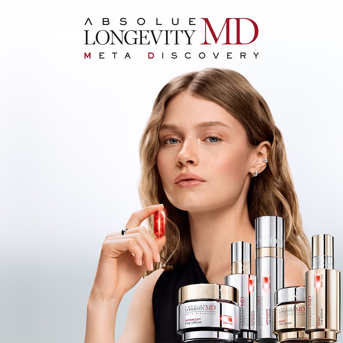 Šis vaizdas pristato „Absolute Longevity MD Meta Discovery“ liniją su modeliu, laikančiu raudoną kapsulę, ir įvairiais sidabriniais bei baltais kremais ir serumais.