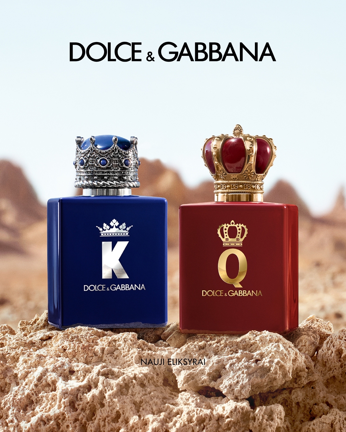 Du Dolce & Gabbana aromatai karališkame įvaizdyje: mėlynas flakonas su sidabrine karūna ir raudonas su aukso karūna ant akmenų fono.