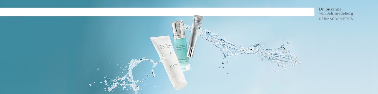 Dr. Susanne von Schmiedeberg DERMACOSMETICS linijos produktai: baltas HYALURONIC drėkinamasis gelinis kremas, melsvas HYALURONIC serumas ir sidabrinis HYALURONIC akių kremas, apsupti vandens purslų.